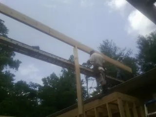 Carpenter setting a ridge beam over a new addition frame — Ice Dam Removal by Roofing Brothers in Sulphur Springs