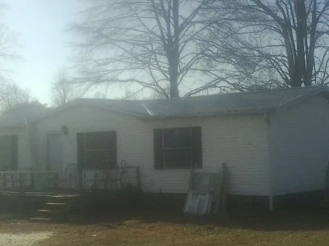 New metal roof on a white painted brick home on a foggy morning in Sulphur Springs