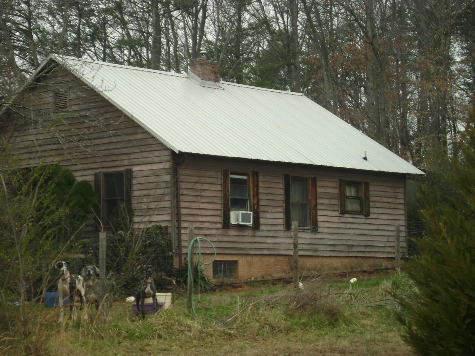 White metal roof on an old wood sided farmhouse, from a Metal Roof Installation job in Sulphur Springs